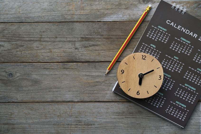 a clock, pencil and calendar sit on a desk to visualise GIS training for a whole year